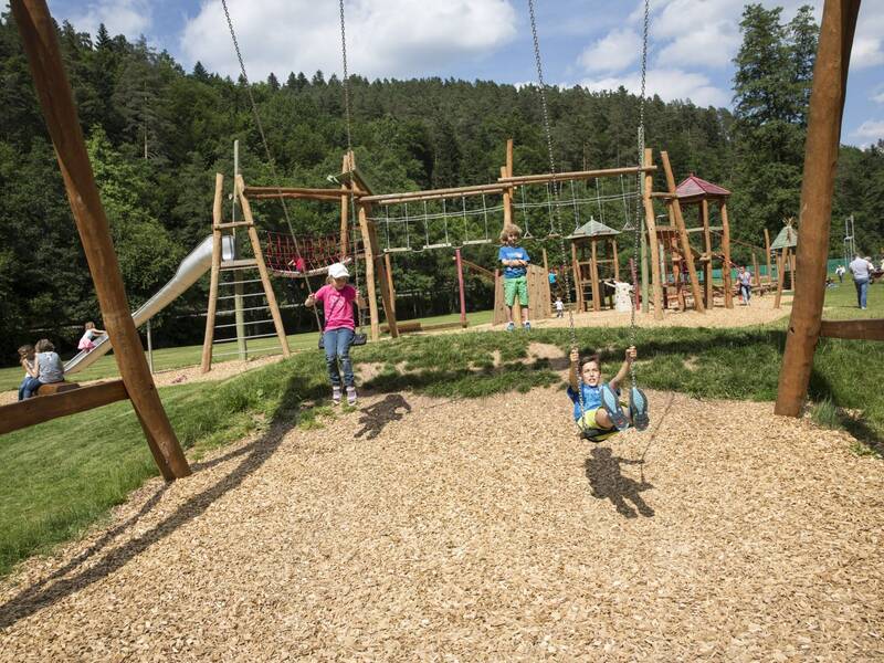 Kinder schaukeln auf dem Spielplatz
