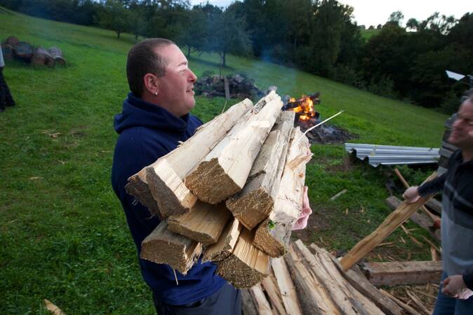 Ein Fackler trägt einige Holzscheite.